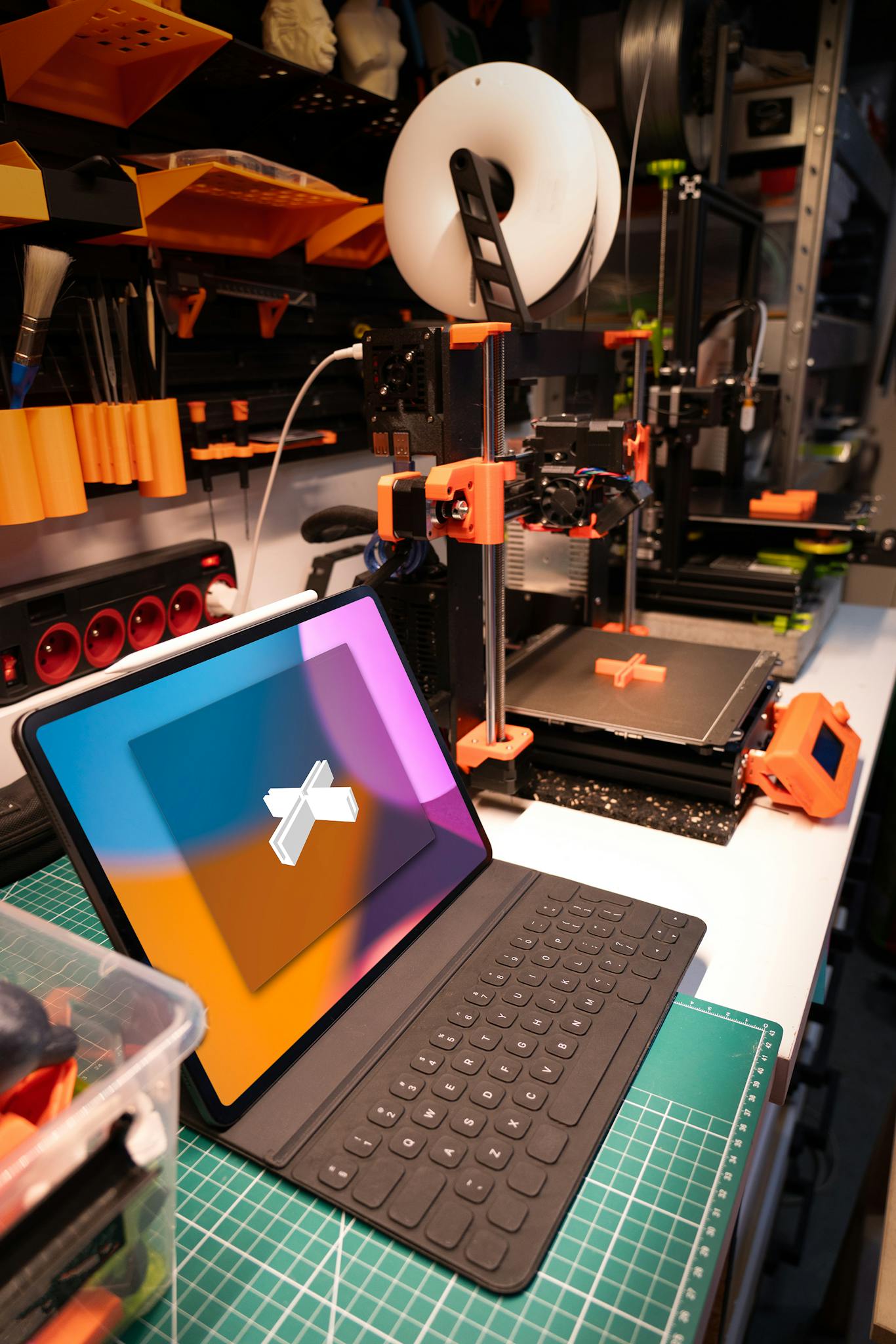 A modern workspace featuring a 3D printer and tablet for creative technology projects.